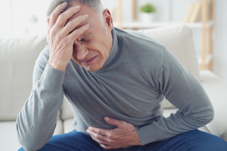 Пожилой мужчина согнулся от боли